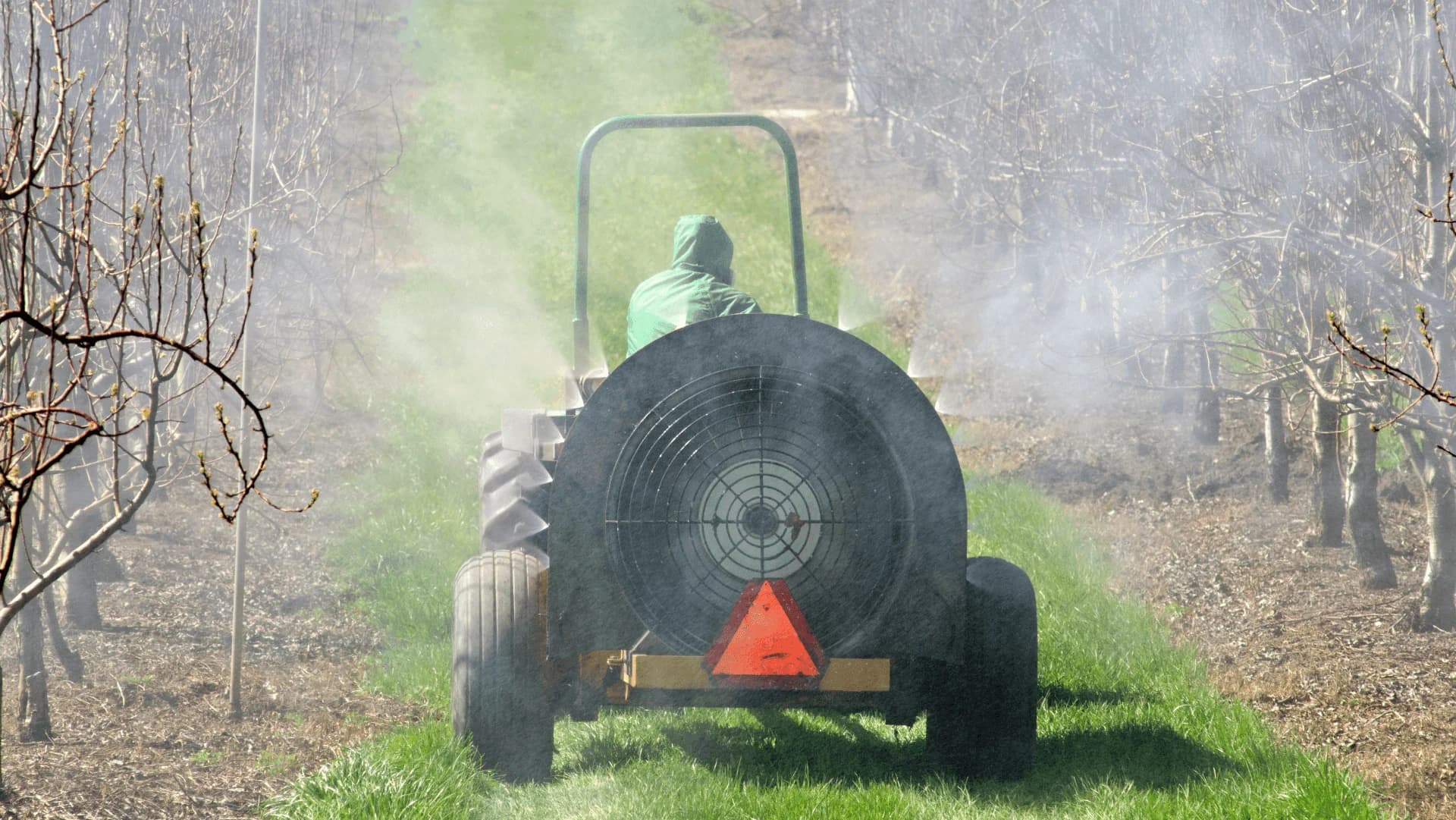 Precision sprayer at work between orchard rows